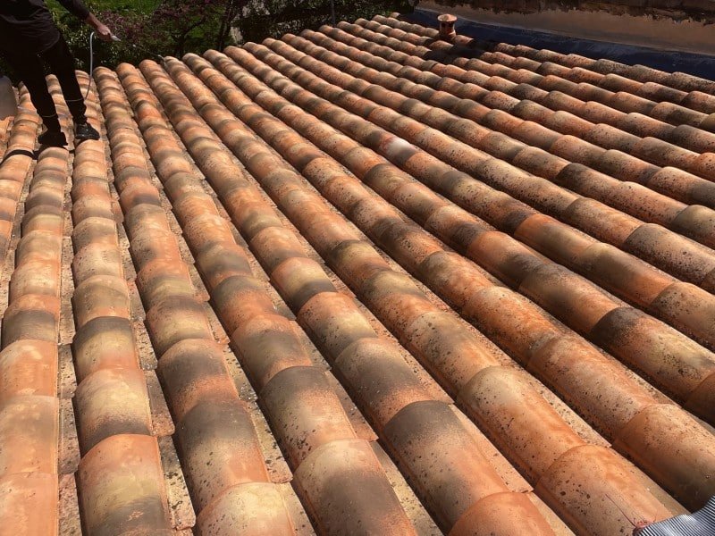 Application au pulvérisateur d'un traitement hydrofuge sur des tuiles propres.